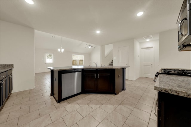 kitchen with ceiling fan, sink, stainless steel appliances, decorative light fixtures, and a kitchen island with sink