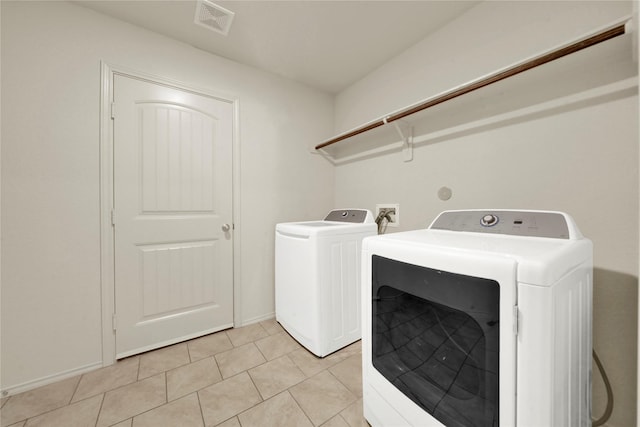 laundry room with separate washer and dryer and light tile patterned floors