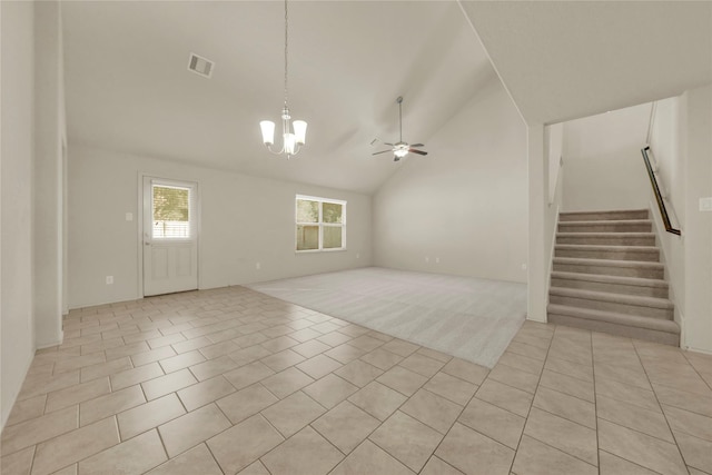 unfurnished living room with ceiling fan with notable chandelier, high vaulted ceiling, and light tile patterned flooring