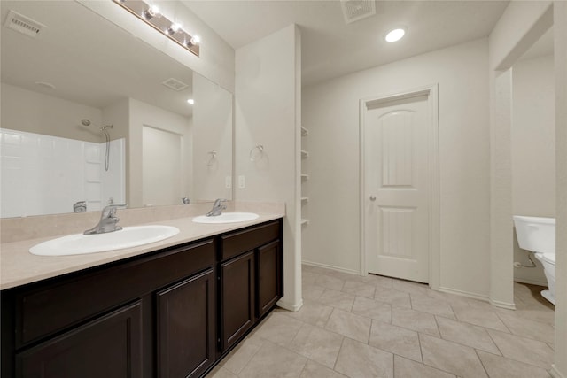 bathroom featuring a shower, tile patterned flooring, vanity, and toilet