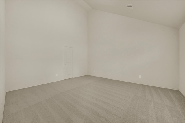 empty room featuring light carpet and vaulted ceiling