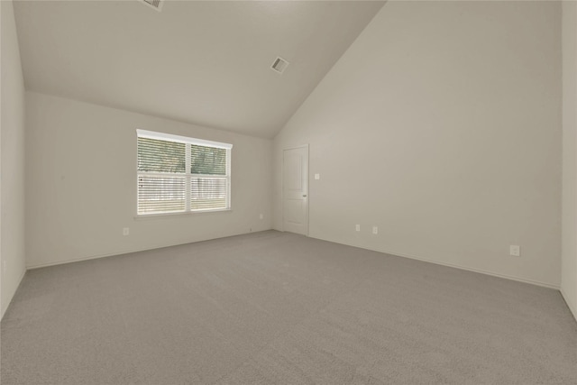 unfurnished room featuring high vaulted ceiling and light colored carpet