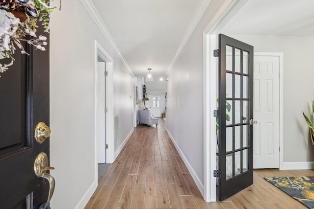 hall featuring light wood-type flooring and crown molding