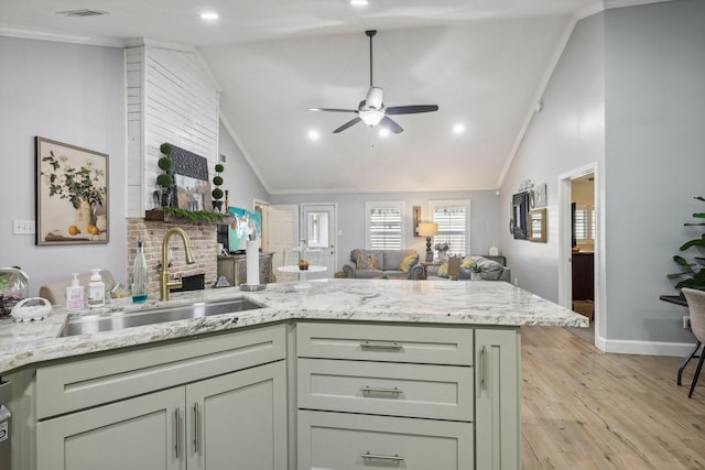 kitchen featuring ceiling fan, sink, crown molding, light hardwood / wood-style floors, and lofted ceiling