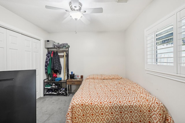 bedroom with ceiling fan, carpet floors, and a closet