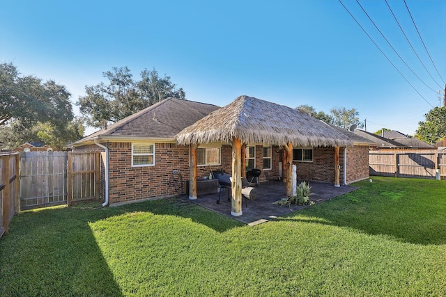 back of property with a patio area and a yard