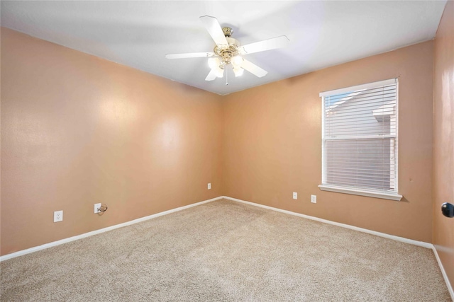 carpeted spare room with ceiling fan