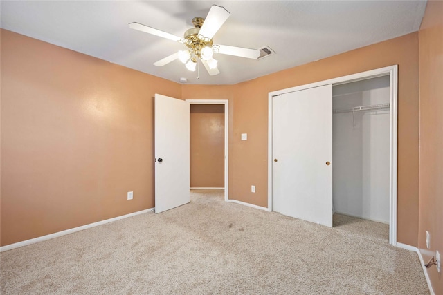 unfurnished bedroom featuring ceiling fan, light colored carpet, and a closet