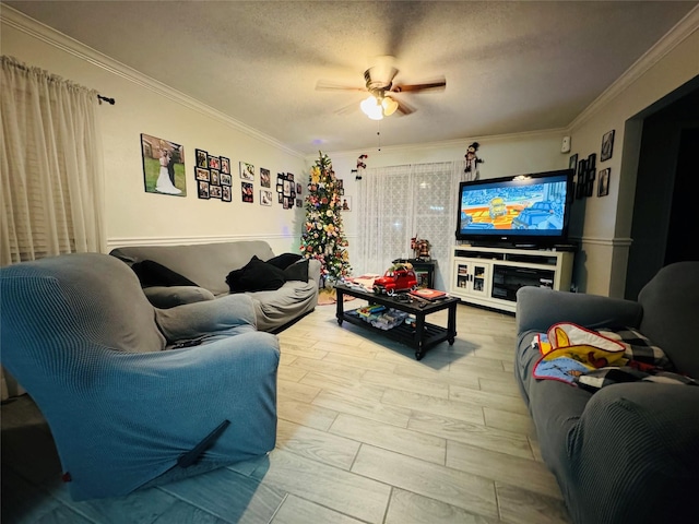 living room with ceiling fan, light hardwood / wood-style flooring, a textured ceiling, and ornamental molding