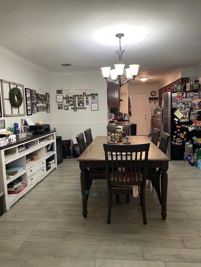 dining area featuring ornamental molding and a notable chandelier