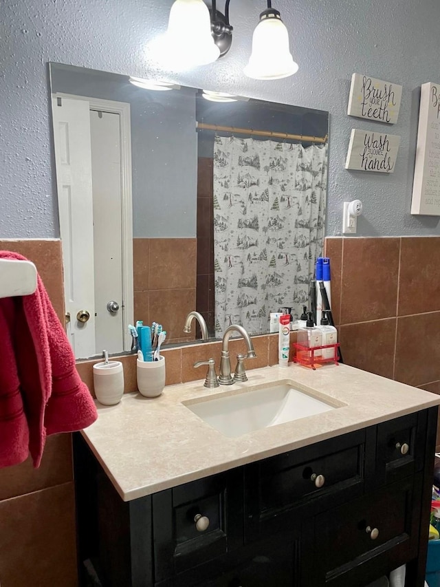 bathroom with vanity, tile walls, and walk in shower