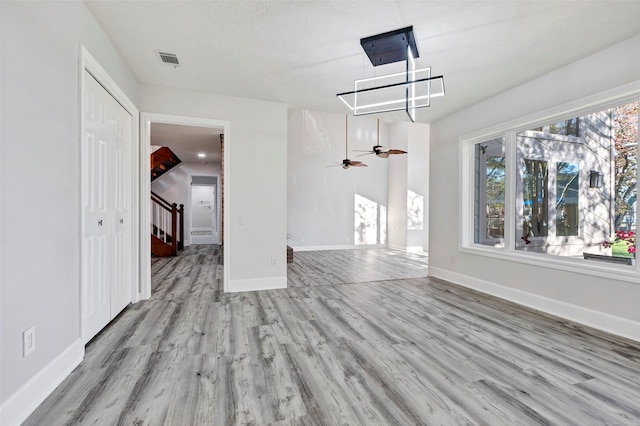 unfurnished living room with light hardwood / wood-style flooring and ceiling fan