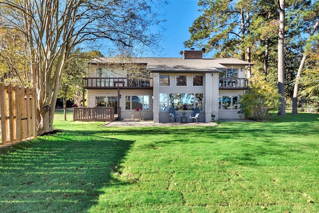 back of property featuring a patio area, a balcony, and a yard