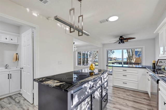 kitchen featuring stainless steel dishwasher, ceiling fan, decorative light fixtures, light hardwood / wood-style floors, and white cabinetry