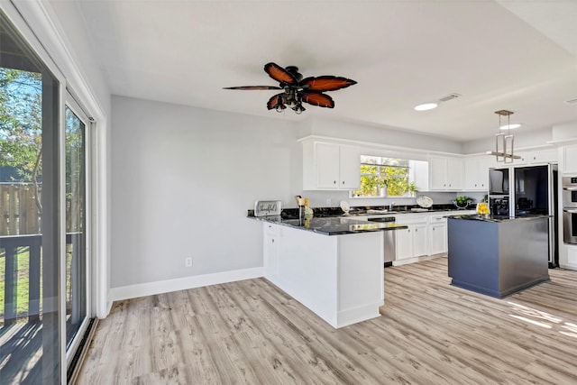 kitchen with white cabinets, light hardwood / wood-style flooring, and a wealth of natural light