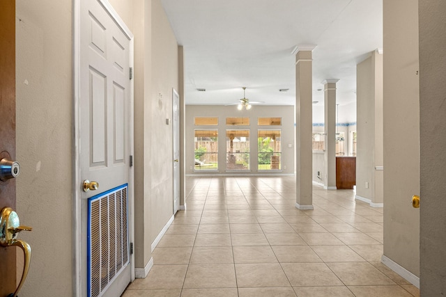 hallway with decorative columns and light tile patterned flooring