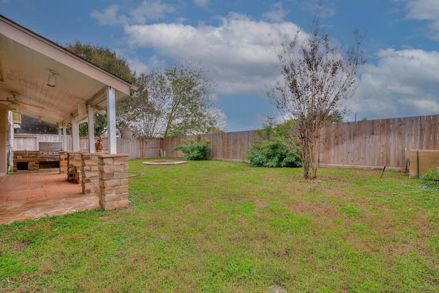 view of yard with ceiling fan and a patio