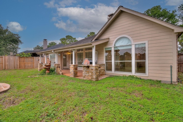 rear view of property with a patio, a yard, and area for grilling