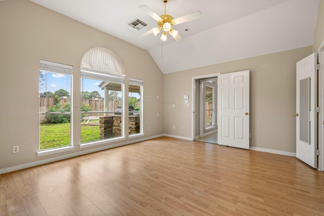 empty room with ceiling fan, a healthy amount of sunlight, light wood-type flooring, and vaulted ceiling