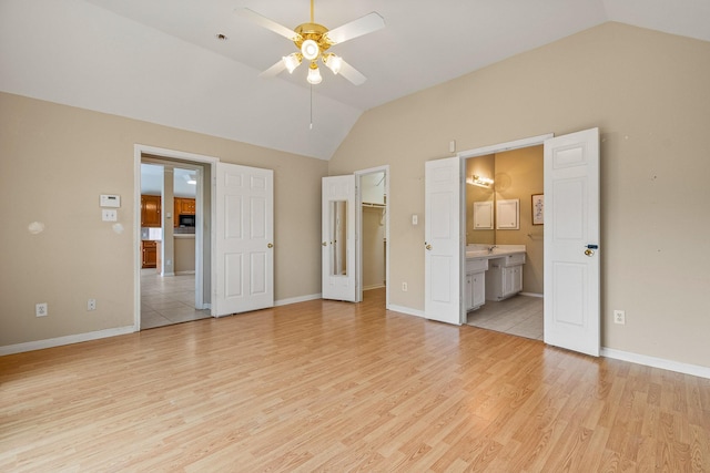 unfurnished bedroom with ceiling fan, light hardwood / wood-style floors, vaulted ceiling, and ensuite bath