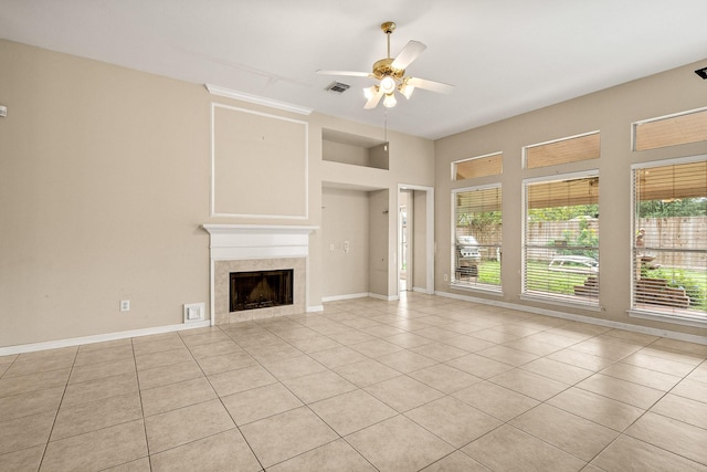 unfurnished living room with a tile fireplace, ceiling fan, and light tile patterned flooring