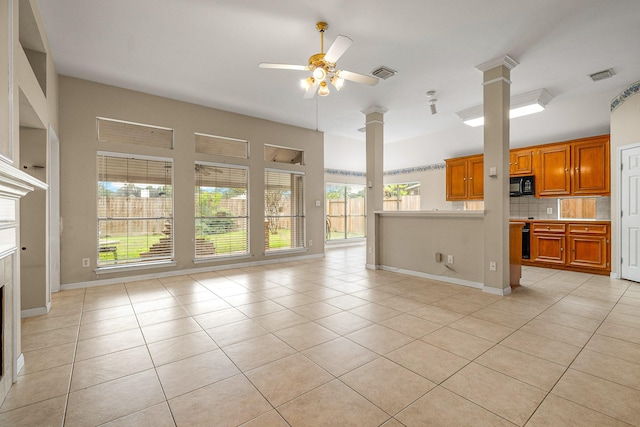 unfurnished living room with decorative columns, ceiling fan, light tile patterned floors, and a healthy amount of sunlight