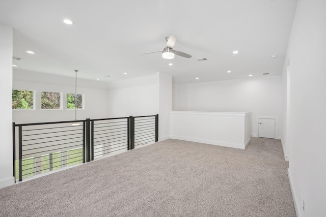 carpeted spare room featuring ceiling fan