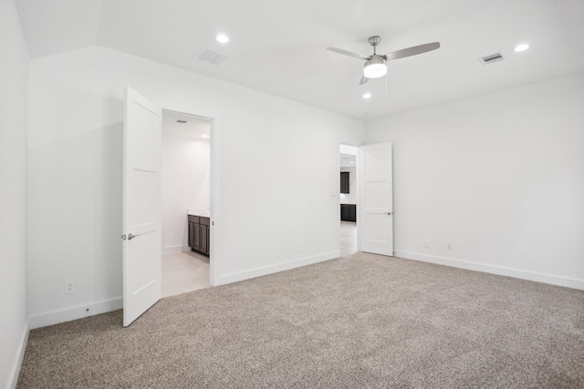 unfurnished room with ceiling fan, lofted ceiling, and light carpet