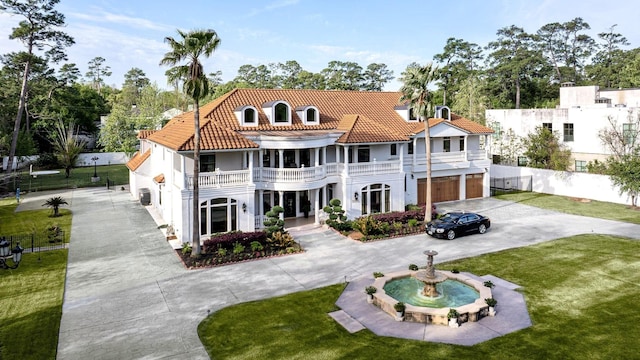 back of house with a balcony, a garage, and a lawn