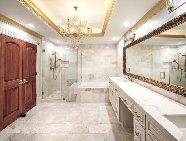 bathroom with a raised ceiling, a chandelier, vanity, independent shower and bath, and tile walls