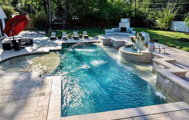 view of swimming pool featuring pool water feature, a patio area, an outdoor living space with a fireplace, and a lawn