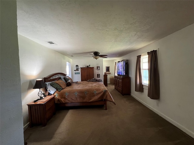 carpeted bedroom featuring ceiling fan and a textured ceiling