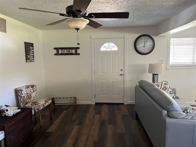 foyer entrance with ceiling fan, dark hardwood / wood-style flooring, and a textured ceiling