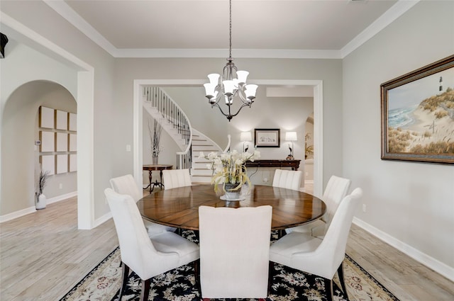 dining space with a chandelier, crown molding, and light hardwood / wood-style floors