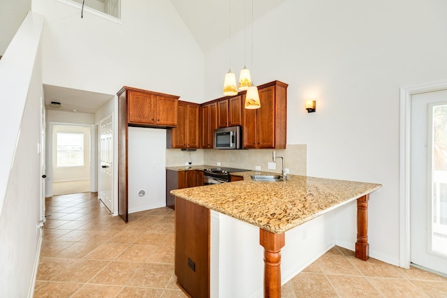 kitchen featuring sink, hanging light fixtures, stainless steel appliances, light stone counters, and high vaulted ceiling