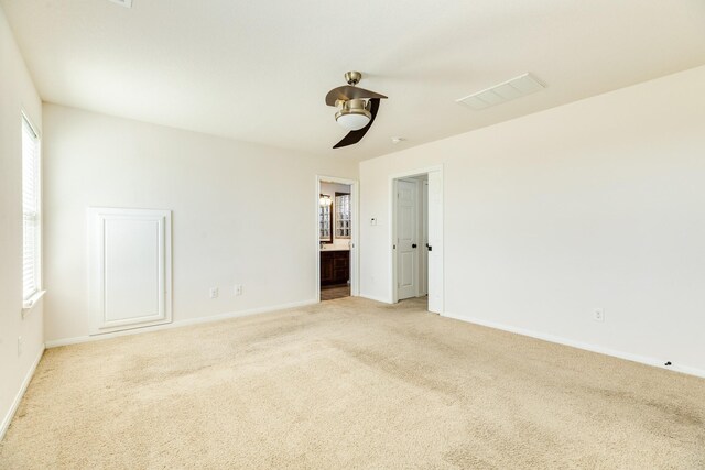 unfurnished room with light colored carpet, ceiling fan, and a healthy amount of sunlight