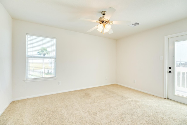 carpeted empty room featuring ceiling fan and a healthy amount of sunlight