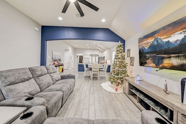 living room featuring lofted ceiling, ceiling fan, and light hardwood / wood-style flooring