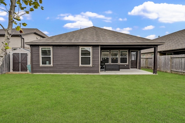 back of property featuring a lawn, a storage shed, and a patio area