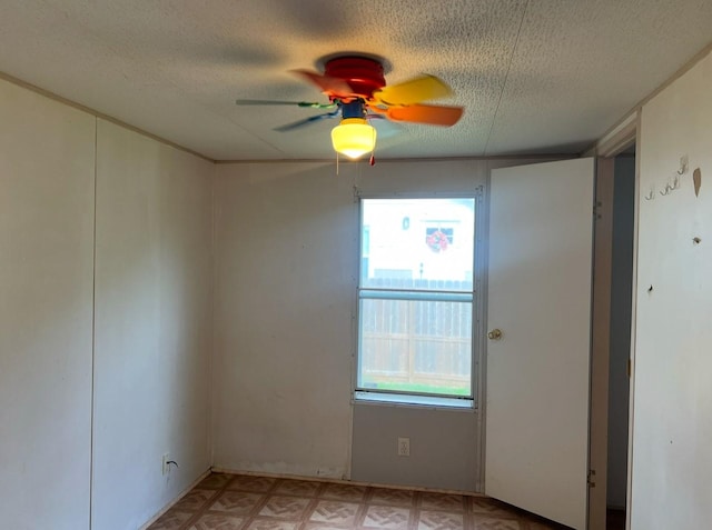 unfurnished room featuring ceiling fan and a textured ceiling