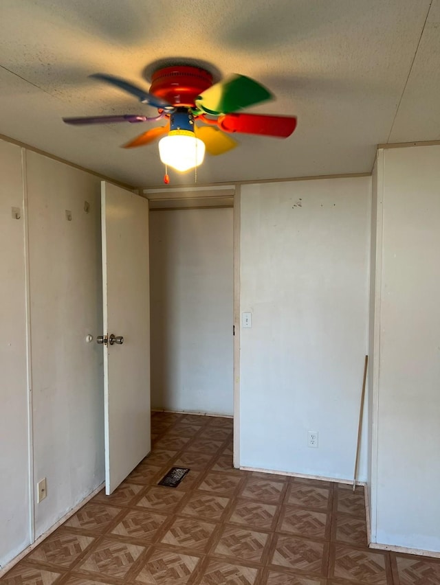 unfurnished bedroom with ceiling fan, light parquet flooring, and a textured ceiling