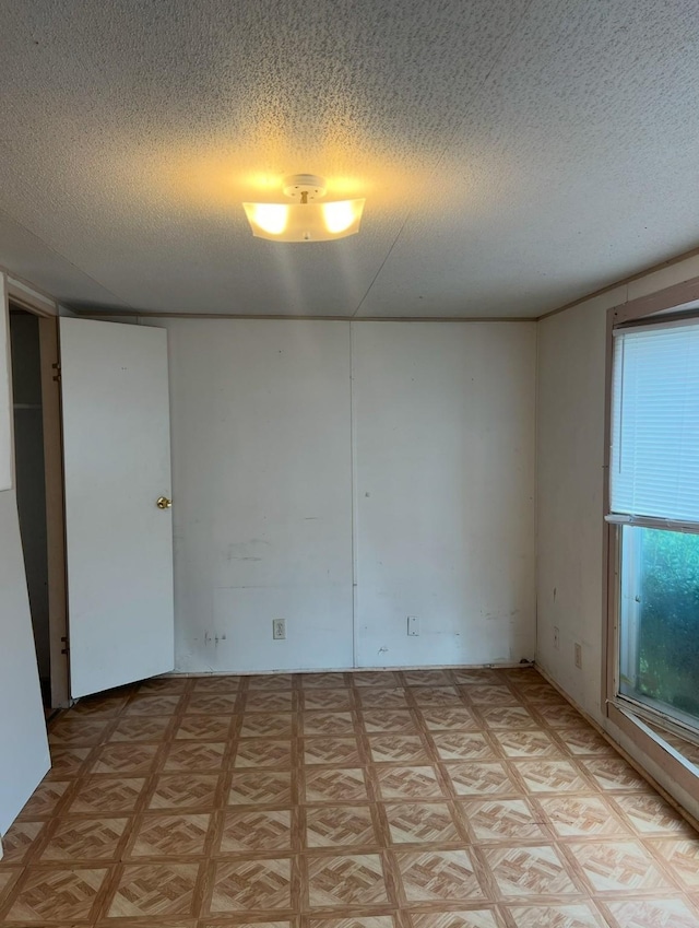 empty room featuring a textured ceiling and light parquet floors