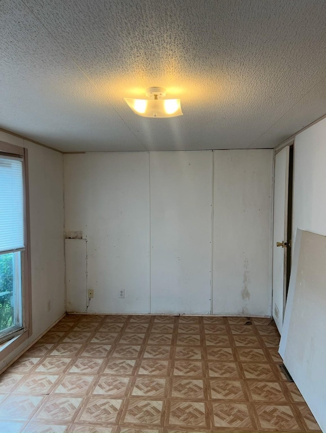 spare room featuring a textured ceiling and light parquet flooring