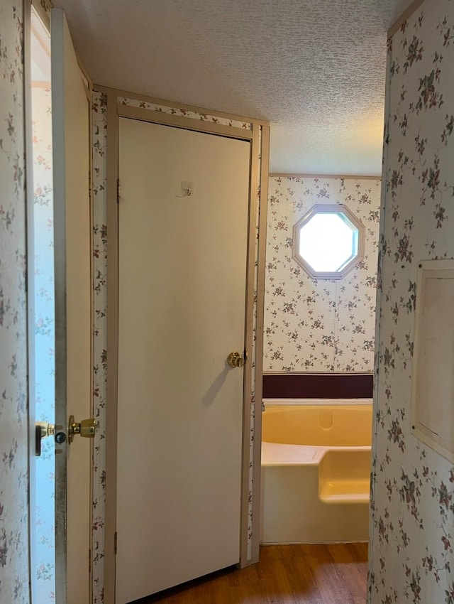 doorway featuring a textured ceiling and light wood-type flooring