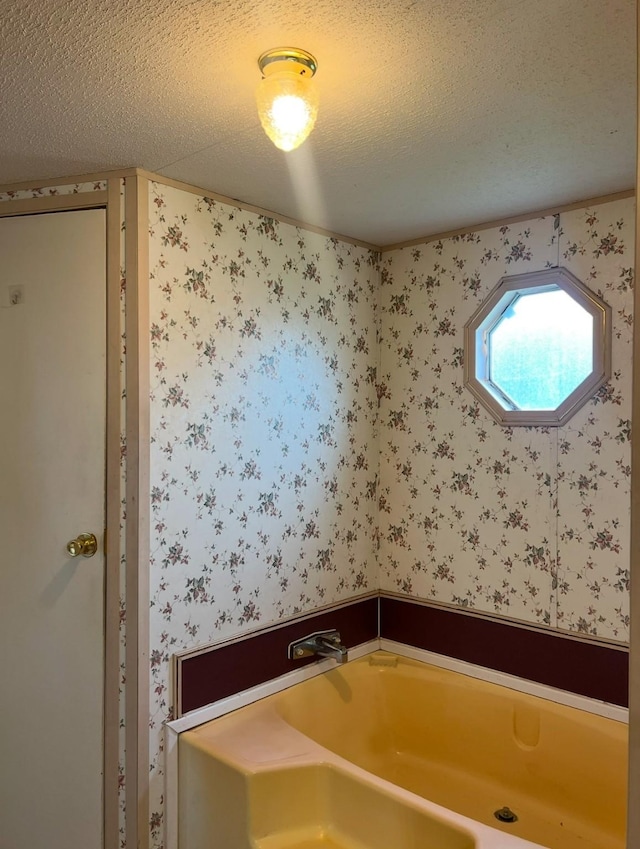 bathroom with a bath and a textured ceiling