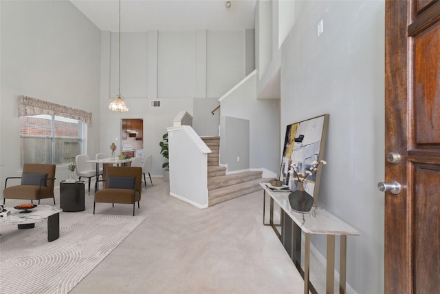 carpeted entrance foyer with a towering ceiling