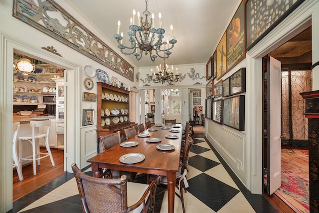 dining area with crown molding, hardwood / wood-style floors, french doors, and a notable chandelier