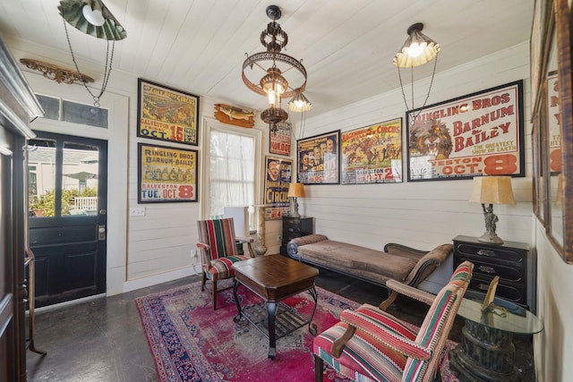 sitting room featuring wooden walls and wood ceiling