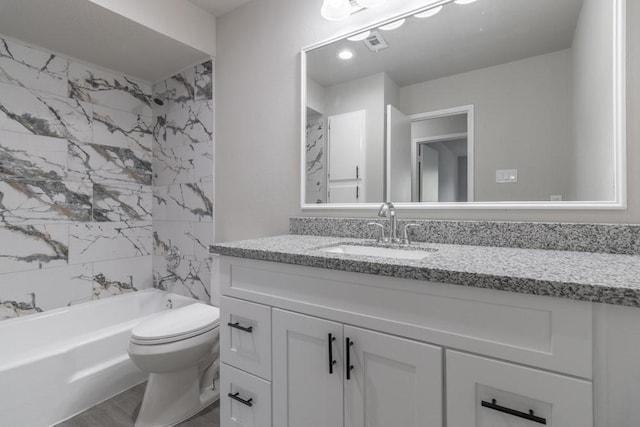 full bathroom with toilet, vanity, and tiled shower / bath combo