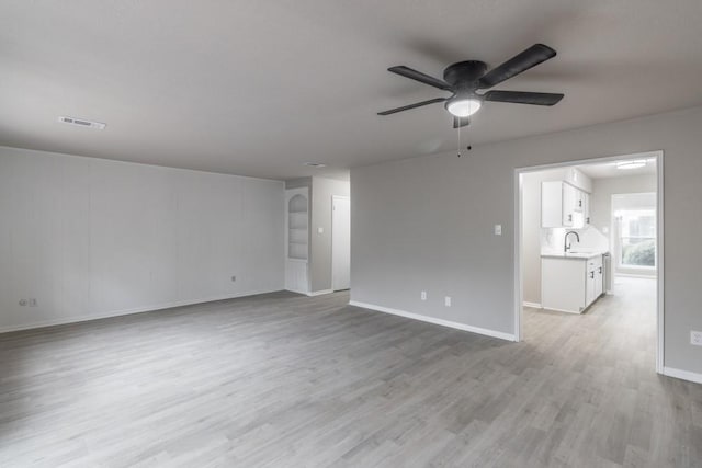 spare room featuring ceiling fan, sink, and light hardwood / wood-style floors